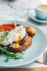 Healthy breakfast from poached eggs, grilled halloumi, Scrambled smoked harissa tofu, smashed avocado, grilled mushrooms and tomato beans on toast