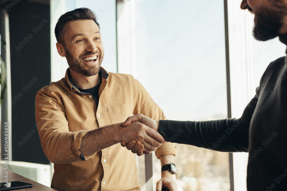 Sticker Business partnership. Two happy businessmen handshaking after successful deal at modern office