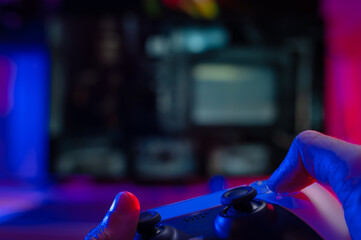 Gamer plays a video game. Technological background. Entertainment, recreation, communication, online competition with friends, new technologies, electronics.