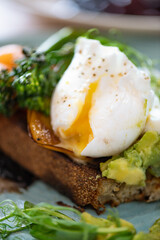 Healthy breakfast from poached eggs, steamed broccolli, salmon, smashed avocado, grilled mushrooms and tomato on toast