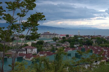 Obraz premium Rain clouds gather over the city. Before a thunderstorm.View of the city from the height of the mountains. Black Sea. Myskhako. Novorossiysk. Russia.