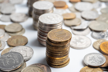 Close-up of a lot of Russian ruble coins on a white background. Some of them are arranged in columns. The concept of wealth, economy, growth, business. Money, coins.