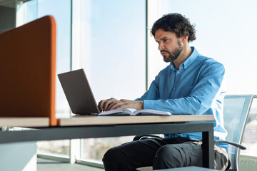 Business man using laptop sitting on chair in office