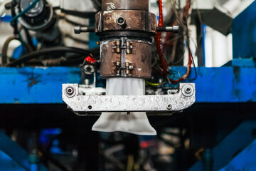 The process of blowing plastic tanks and canister in extrusion equipment. Molten white plastic like...