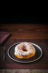 Tasty donuts insulated with white chocolate sprinkled with chocolate chips on a plate on a fine table. Fine pastries, Copy space