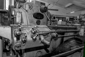 Fototapeta na wymiar Metalworking workshop, metal processing machines. Vintage Industrial Machinery in a old factory - black and white photo