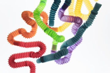 Trendy kids toys â€” colorful pop tubes on white background. Set of different forms and colors corrugated pipe.