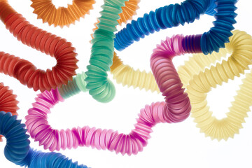Trendy kids toys â€” colorful pop tubes on white background. Set of different forms and colors corrugated pipe.