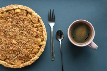 Homemade sweet apple pie and  cup of coffee on the side on grey background. Top view.