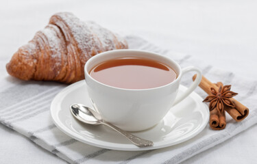 Tea, fresh French croissant, star anise and cinnamon sticks. Cafe breakfast concept