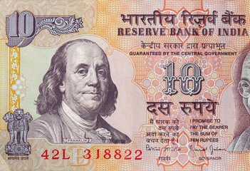 old 10 Indian rupee obverse with superimposed Benjamin Franklin from 100 dollar banknote
