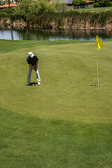 Obraz premium Male golfer on profession golf course in a tournament putting on the green