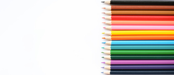 A set of colored pencils isolated on a white background in banner format. Place for text