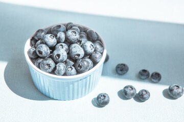 Blueberry berries in blue bowl on the table, beautiful card with still life