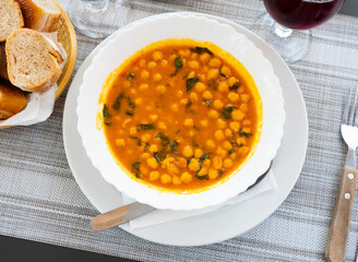 Delicious flavourful chickpea and spinach curry stew served on white plate. Typical Spanish dish