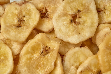 Banana chips background top view. Dried banana slices texture. Heap of dried bananas.