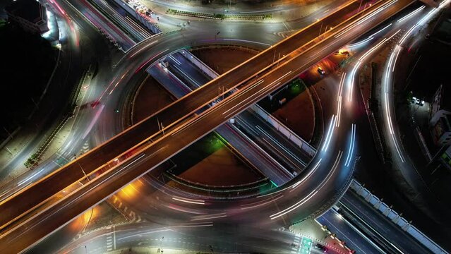 Hyperlapse time-lapse of car traffic transportation above circle roundabout road in Asian city. Drone aerial view fly in circle, high angle. Public transport or commuter city life concept	
