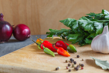 Peppers,garlic,onions and herbs on athe kitchen board