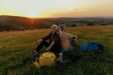 Traveler couple sitting on meadow while taking a break