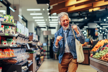 Senior man listening music at the supermarket