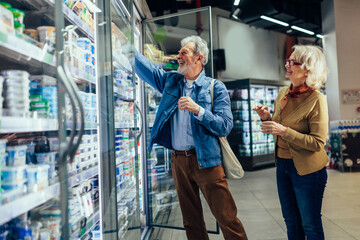 Senior couple choosing groceries in supermarket