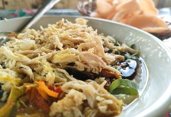 rice with chicken. Indonesian food called Bubur Ayam. Rice is made into porridge with various toppings sprinkled with chicken swir on top.