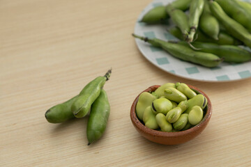 fresh peeled and shelled broad beans on plates with copy space