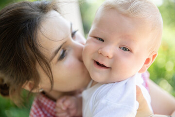 Young mother hugging and kissing her son