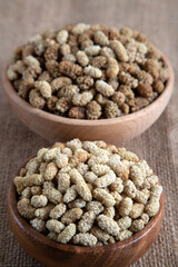 Bowl full of dried mulberry on a fabric background
