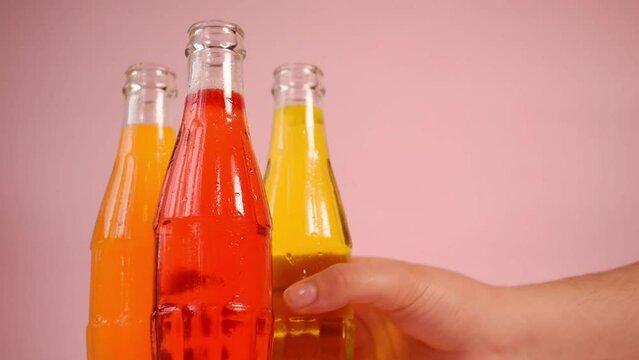 Hand taking a colorful cold soda bottle