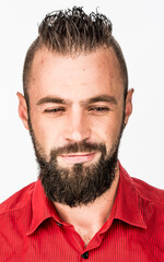 Obraz premium funny guy with a beard in a red shirt close-up shows different emotions. cheerful kind sad surprised satisfied range of emotions