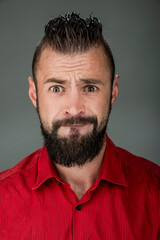 Obraz premium funny guy with a beard in a red shirt close-up shows different emotions. cheerful kind sad surprised satisfied range of emotions