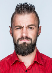 Obraz premium funny guy with a beard in a red shirt close-up shows different emotions. cheerful kind sad surprised satisfied range of emotions