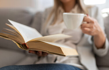 Woman with book and coffee. Stay at home concept.