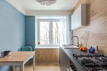 Minimalist kitchen with handleless fronts, no tall cabinets. Budget renovation in housing, area of ​​ten square meters