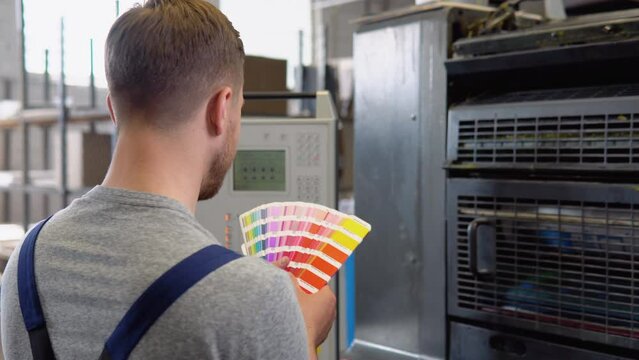 Graphic designer choosing colors from color palette. Concept of color management in the print production process. Catalog samples for printing proofing