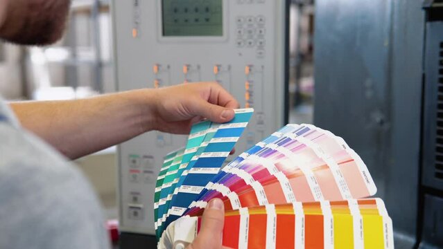 Graphic designer choosing colors from color palette. Concept of color management in the print production process. Catalog samples for printing proofing