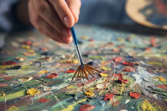 the artist paints with a brush in his hand