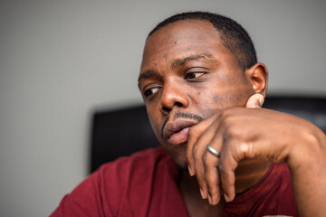 Depressed and anxious African American or black man sitting at home