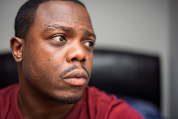 Obraz premium Depressed and anxious African American or black man sitting at home