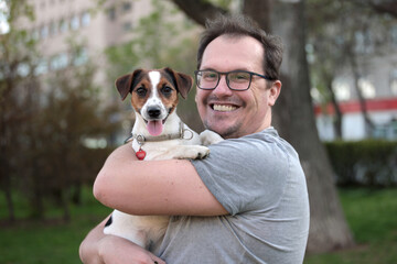 Positive man with a dog in his arms