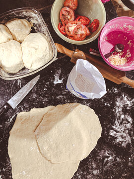 Prepara&ccedil;&atilde;o para fazer pizza. Mise en place. Farinha, queijo mussarela, tomate e massa de pizza com muita farinha.