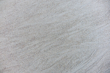 Sand background and texture. Wet beach sand texture after low tide. Sand with wave print. Ripple on the beach sand. 