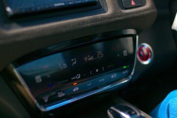 close up of a car dashboard, hybrid electric car dashboard climate control system with capacitive touch LED display, temperature controls, fan speed controls, airflow, air circulation; infotainment