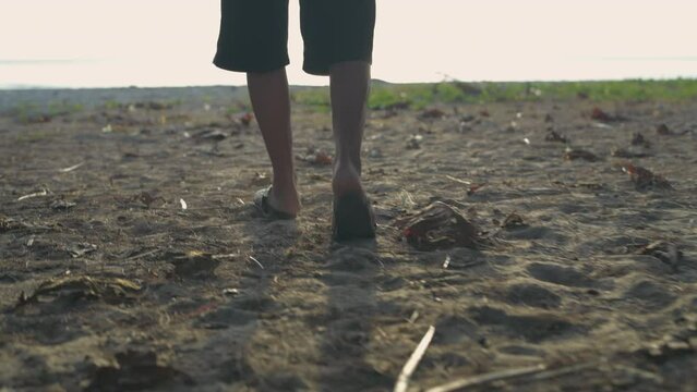 Travel concept of 4k Resolution. An old woman walking on the beach.