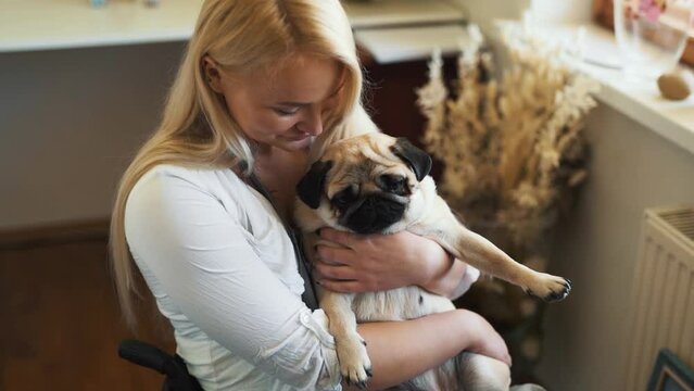 disabled woman in wheelchair hugging pug