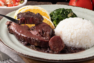 Tasting Brazilian traditional food feijoada.