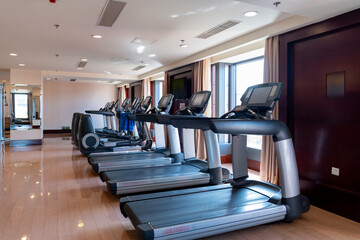 Modern light gym. Sports equipment in gym. Barbells of different weight on rack.