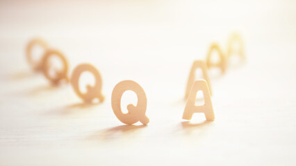 Q A or Questions and answers on wood text with sunshine background.
