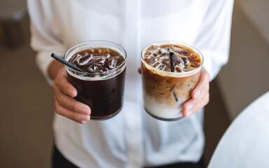 Closeup of a woman holding two glasses of iced coffee